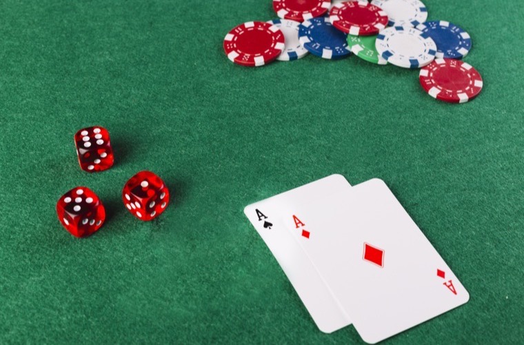 Cartas, dados y fichas sobre el tapete verde de una mesa