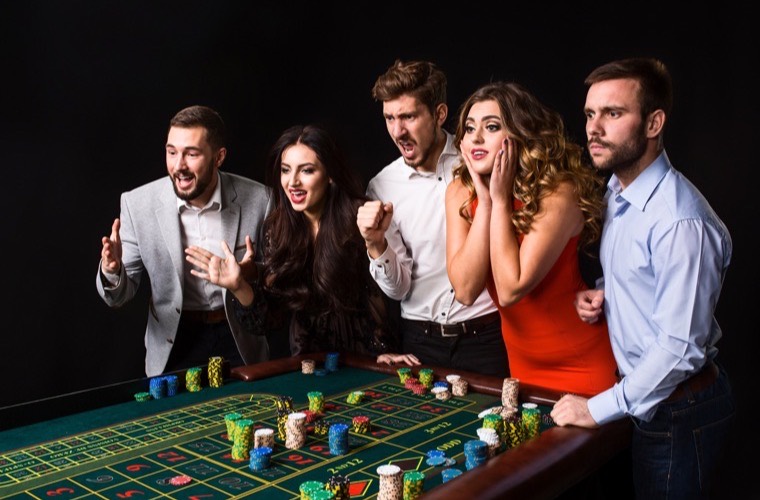 Jugadores siguiendo una ronda en la mesa de ruleta